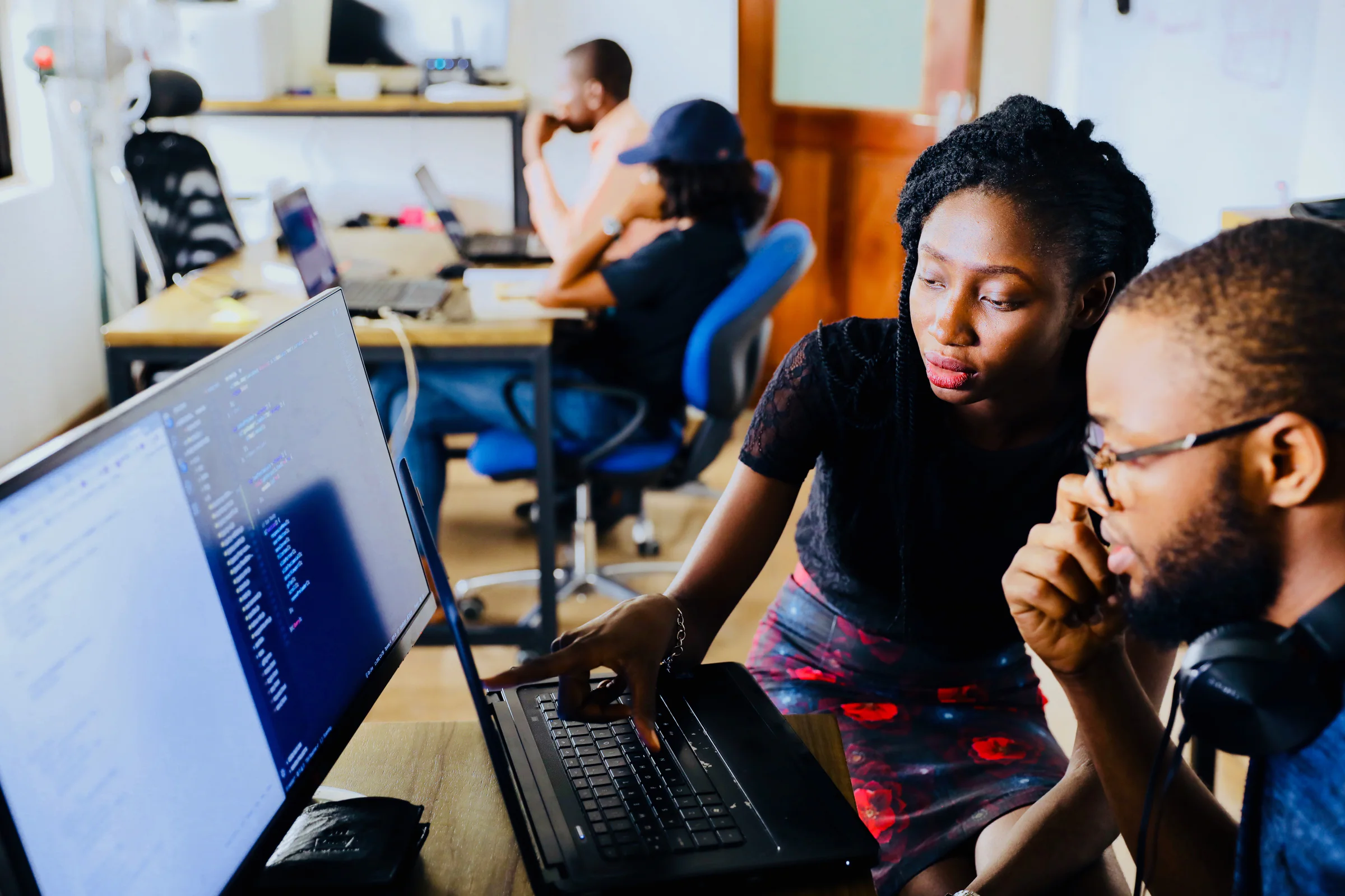 Software engineers collaborating on application code in a shared workspace